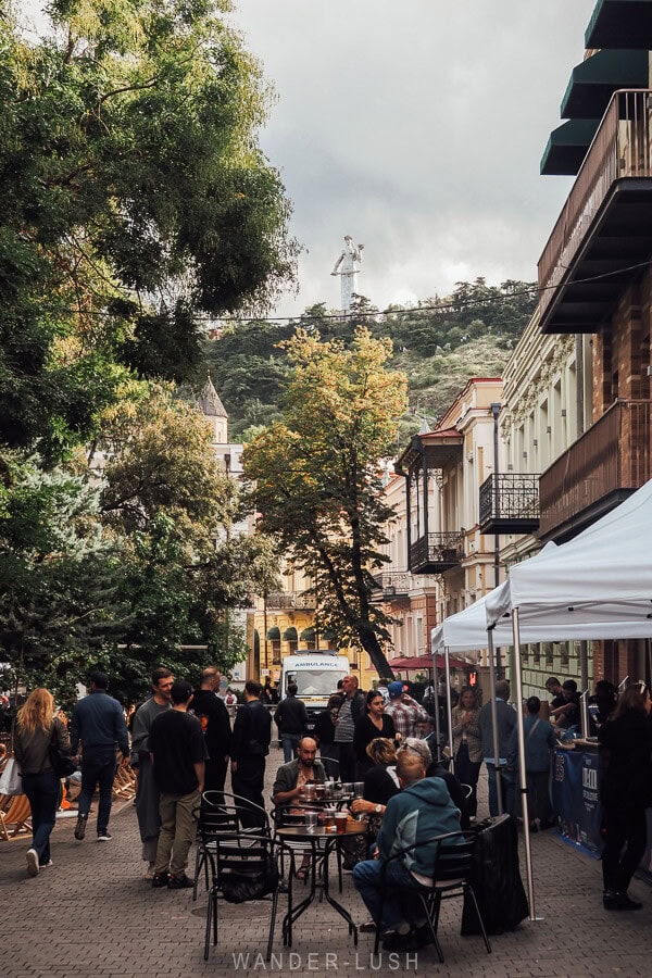 People eat at tables in Gudiashvili Square during the Tbilisoba festival.